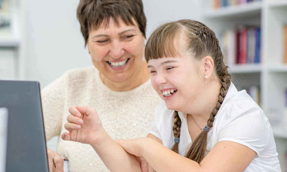 Teacher smiling with young SEND pupil