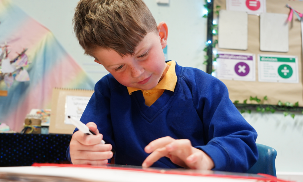 Primary children working at their classroom desk